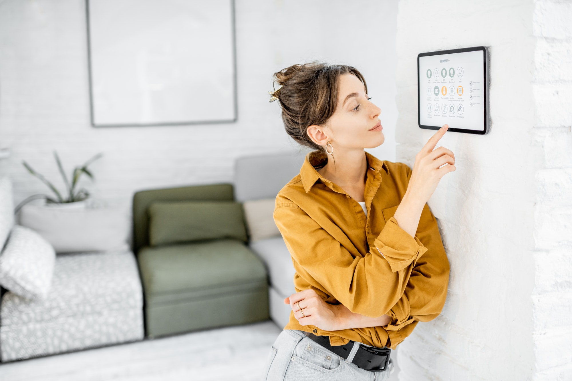 Woman controlling home with a digital touch screen