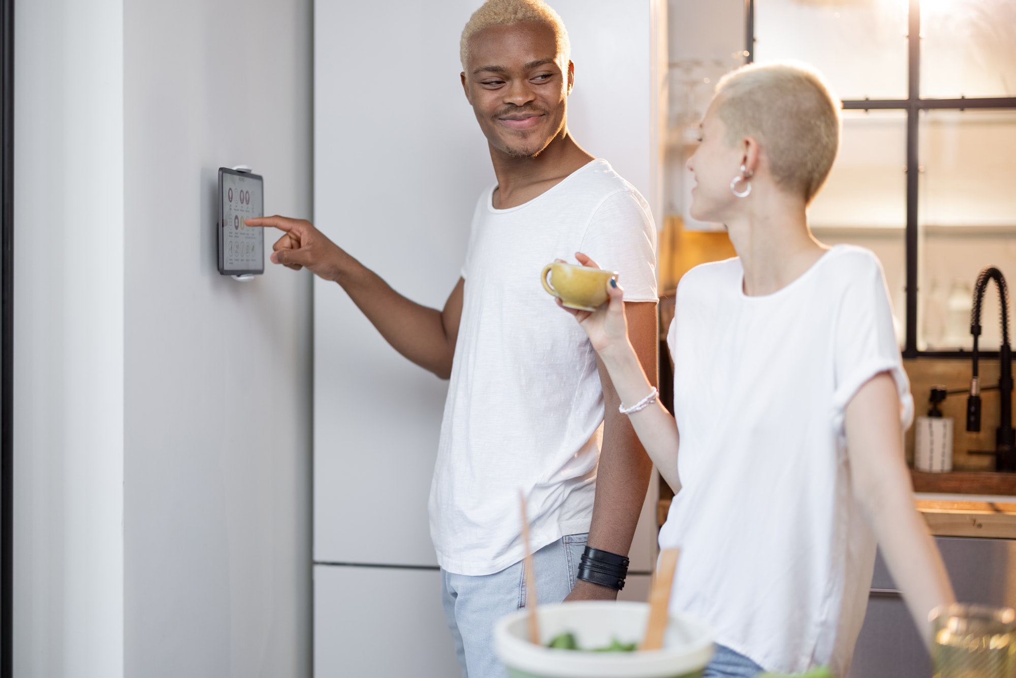 Man choosing temperature of smart home near girl